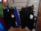 deux pantalons suspendus à un portant dans une pièce