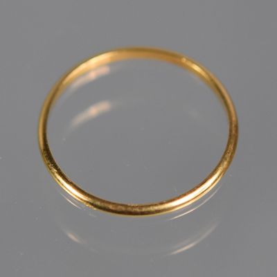 gros plan d'une bague en or sur une surface blanche