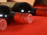 three bottles of wine sitting on a red cloth