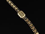 a gold watch with a black and white chain strap