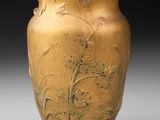 un vase en or orné d'un motif représentant des fleurs et des oiseaux