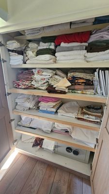 un placard dont les étagères sont remplies de vêtements