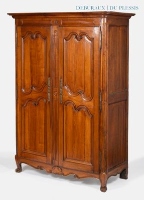 une armoire ancienne en bois, avec un dessus sculpté et deux portes