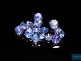a close up of a bunch of blue sapphires on a black surface