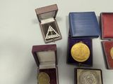 five different types of gold medals in a box
