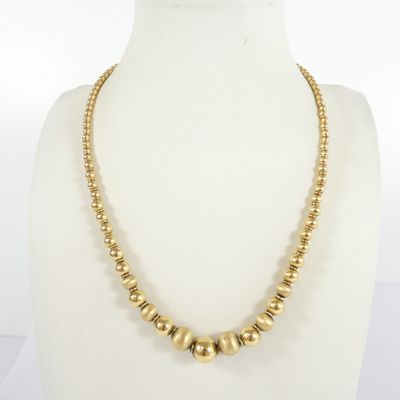 a gold beaded necklace on a mannequin mannequin mannequin mannequin mannequin mannequin mannequin mannequin mann