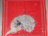 une écharpe rouge sur laquelle est représenté un oiseau blanc et noir