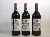 trois bouteilles de vin sont alignées sur une surface blanche