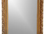 un miroir à cadre doré, orné d'un motif décoratif sur fond blanc