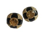 paire de boucles d'oreilles noires et dorées ornées d'un cristal jaune au centre