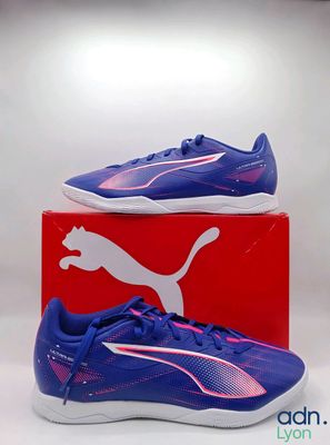 une paire de chaussures Puma posée sur une boîte rouge