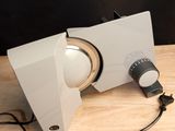 a white speaker sitting on top of a wooden table