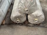 many rolls of metal on a pallet in a warehouse
