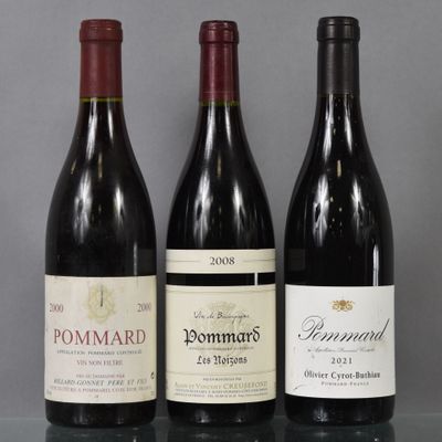 three bottles of wine are lined up on a glass table