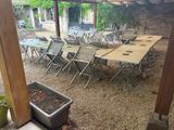 many tables and chairs set up under a pergol roof