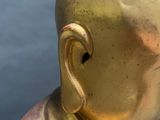 an image of a gold statue of a man with a bald head