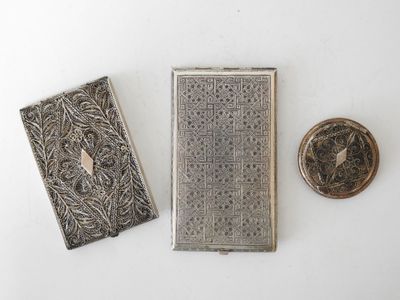 three antique silver cigarette cases and a small silver cigarette case
