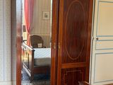 an image of a bedroom with a bed, dresser and mirror