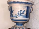 a blue and white vase sitting on a wooden table