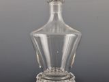 a clear glass bottle with a crown on the top