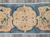 un tapis chinois ancien orné de fleurs et de rinceaux bleus et jaunes