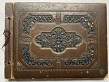 un vieux livre relié en cuir, dont la couverture est ornée d'un motif décoratif