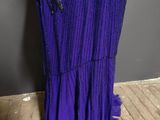 a woman in a purple dress standing on a wooden floor