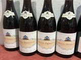 six bottles of wine are lined up on a table