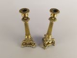 pair of antique brass candlesticks on a white background