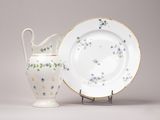 une assiette blanche et un vase blanc orné de fleurs bleues