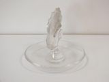 a clear glass object on a clear plate on a white surface