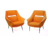 une paire de chaises orange aux pieds noirs sur fond blanc