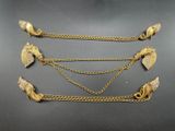 a group of four gold chain bracelets on a black surface
