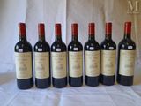 six bottles of wine are lined up on a table