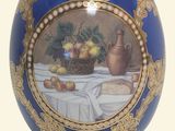 a blue and gold egg with a picture of fruit on it
