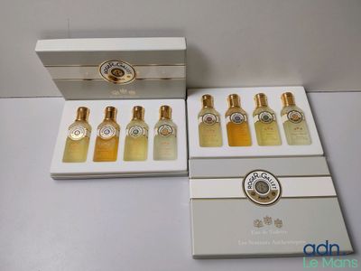 quatre flacons de parfum dans une boîte blanche posée sur une table