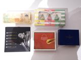 four different boxes of perfumes on a white surface