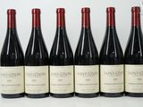 six bottles of wine are lined up on a table