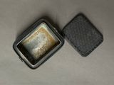 a small metal container with a square piece of food inside of it