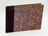an old book with a red cover and a swirly pattern on it