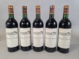 quatre bouteilles de vin sont alignées sur une table