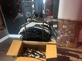 a box of clothes sitting on the floor next to a pile of clothes