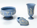 a blue vase and a pair of shoes next to each other