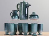 cinq tasses et un pichet sur la table