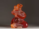 a red and orange gummy bear sitting on a white surface