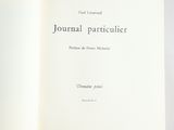 an open book on a table with a white cover and black writing