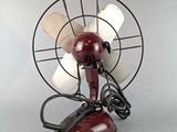 a small red fan sitting on top of a table