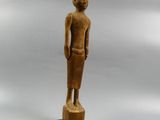 a wooden statue of a man standing on top of a wooden base