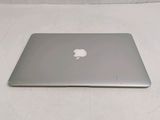 a silver apple laptop sitting on a white surface