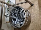 a metal bucket with a whisk in it hanging on a wall